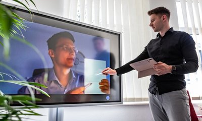 Nikita Soldatov erläutert in der Burgstädter Nachhilfeschule "Schülertreff" die Funktion einer neuangeschafften interaktiven Tafel. Marek Pijala ist dabei online aus Bratislava zugeschaltet. 