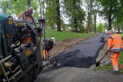 Am Freitag baute ein Team der Firma UTR die Schwarzdecke in den neuen Weg im Stadtpark ein. Am Montag soll die Strecke für Fußgänger, Radler und Rollstuhlfahrer freigegeben werden.