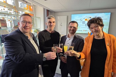 Der Oelsnitzer OB Mario Horn stößt mit den Geschäftsführern Daniel Petri (Oelsnitzer Kultur GmbH), Patrick Reich-Schellenberg (Oelsnitzer Wohnungsbaugesellschaft) und Ines Puhan (Stadtwerke Oelsnitz, von links) auf die neue Service-Welt am Marktplatz an.