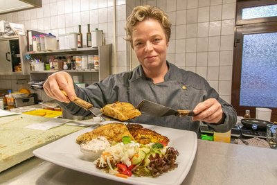 Köchin Susan Förster richtet einen Teller mit Barramundi an.