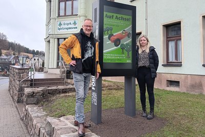Digital informiert: Tino Günther und Stephanie Böhme an der Stele vor dem Spielzeugmuseum.