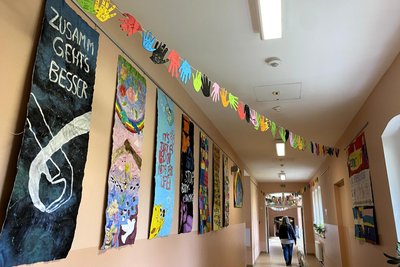 Im Schulgebäude können sich die Besucher zum Tag der offenen Tür umsehen. Alle Schülerinnen und Schüler sowie die Lehrer haben mit ihren Händen aus Papier Girlanden gestaltet.