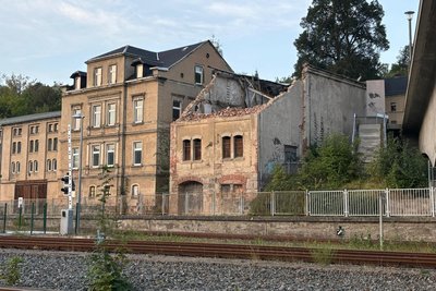 In Aue ist dieses Gebäude diese Woche nur zur Hälfte abgerissen worden. Das Dach und das Obergeschoss brach ein großer Bagger ab, weil sie einzustürzen drohten. Die untere Haushälfte ließen die Bauarbeiter stehen.