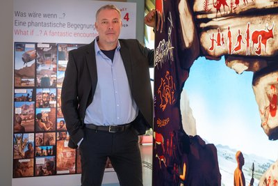 Jörg Linstädter steht neben einer der Boxen durch die den Besuchern verschiedene Perspektiven auf den afrikanischen Kontinent geboten werden sollen.