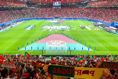 Die Eröffnung in der Leipziger Arena: Während die Spieler den Nationalhymnen lauschen, stehen die Tänzerinnen am Banner ihnen gegenüber im Bild links.