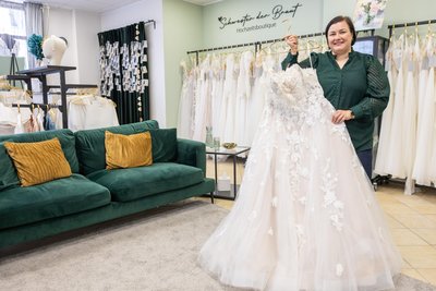 Ein Curvy-Prinzessinnenkleid hält Susann Buschmann von der Hochzeitsboutique „Schwester der Braut“ in Freiberg in den Händen.