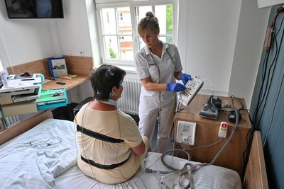 Schwester Andrea Lauterbach verkabelt Patientin Marion Klose vor dem Zu-Bett-gehen mit 18 Kabeln und zwei Gurten.