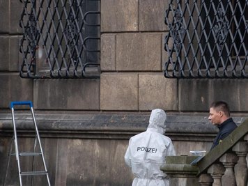             Einsatzkräfte der Polizei stehen neben dem durchtrennten Gitterfenster (links) des Grünen Gewölbes.