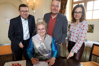 Silberstadtkönigin Laura I. (vorn) unterschreibt den Vertrag für ihre zweite Amtszeit in Freiberg. Mit dabei: Anja Fiedler, Leiterin des Amtes Kultur-Stadt-Marketing, Oberbürgermeister Sven Krüger (v.r.) und Holger Scheich, Vorstand des Vereins Freiberg.Science.City.
