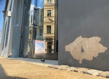 Neben der Eingangstür ist auf beiden Seiten die Farbe abgefallen. 