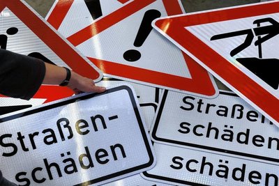 Wo allzu große Gefahren durch Straßenschäden lauern, werden bis zur Reparatur oft Warnschilder aufgestellt. 