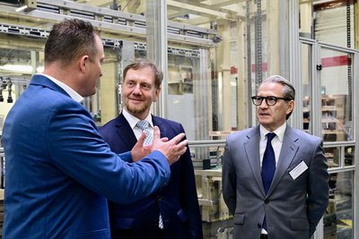 Im Gespräch bei der Übergabe der 100-milllionsten AGM-Batterie: Werkleiter Kai Mille, Ministerpräsident Michael Kretschmer und Europa-Chef Werner Benade (v. li.).