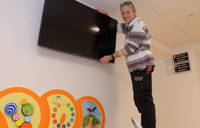 Ute Jeremies, eigentlich Hausmeisterin in der Oberschule Beierfeld, hilft bei den letzten Handgriffen im neuen Bürgeramt Beierfeld, das nächste Woche öffnet. Ein großer Bildschirm informiert die Besucher im Wartebereich. Für Kinder wurde auch an Spielelemente zum Zeitvertreib gedacht. 