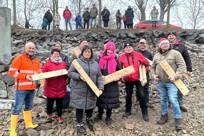Mitglieder des Ortschaftsrates Schönerstadt setzen zur Einweihung symbolisch die Bretter in den Mönch des Teiches.
