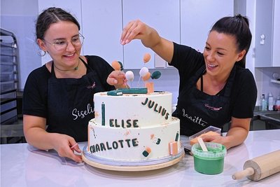 Siselia Mädler (links) und Janette Graf von der Firma "Einzelstücke" bei den letzten Dekorationsdetails für eine Torte zum Schulanfang. 