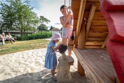 Denise und Nadja testen das Kleinkinderspielgerät mit einem Aufzug für einen Sandeimer.