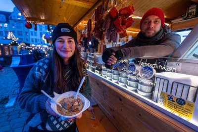 Muriep Gründling und Hannes Petrick servieren auf dem Weihnachtsmarkt Mutzbraten mit Sauerkraut und bieten verschiedene Wurstspezialitäten an.