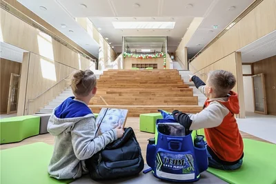 Das Atrium ist das Herzstück der Schule. Dank Oberlichter ist der Innenhof lichtdurchflutet. Die Sitzstufen (Mitte) und die Fläche davor lassen sich als Theater nutzen. Oben in der Mitte: der gläserne Medienraum. 