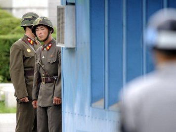 Sichtkontakt: Nordkoreanische Soldaten (im Hintergrund) beobachten im Grenzort Panmunjom einen südkoreanischen Militärangehörigen.