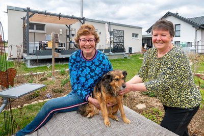 Zwei glückliche Tiny-House-Besitzerinnen: Silke und Kerstin Gampe (von links). Auch Hündin Finny fühlt sich wohl.