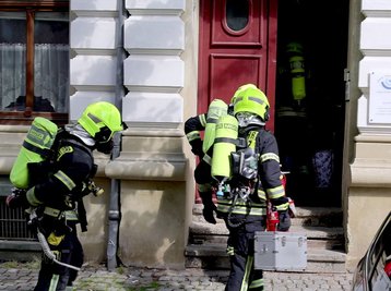 Mit Atemschutzausrüstung betreten Einsatzkräfte das Haus.