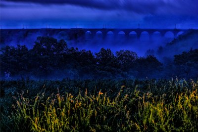 Die Göltzschtalbrücke ragt aus dem Morgennebel, aufgenommen auf dem Aussichtspunkt an der Baumschaukel.