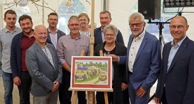 Die Bietergemeinschaft aus Reihen der Stadtverwaltung und des Stadtrates verabschiedete Bernd Pohlers (2. von rechts) mit der von ihr ersteigerten Karikatur von Veit Schenderlein in den Ruhestand.