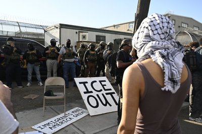 Vor Bundesbeamten der Einwanderungsbehörde ICE haben Demonstrierende ein großes Schild mit der Aufschrift "ICE out" drapiert.