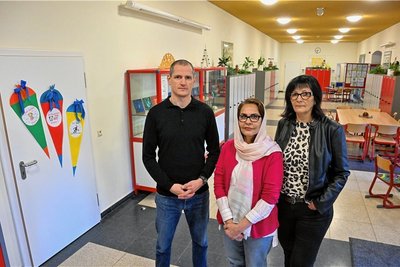 Jörg Seidel vom Elternrat und Schulleiterin Jana Flechsig stehen hinter Integrationsbegleiterin Hajar Sahan. Sie ist an der Grund- und Oberschule der Annenschule in Chemnitz im Einsatz. Einen Schulalltag ohne sie hätte gravierende Folgen, so die Betroffenen.