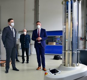 Geschäftsführer Paul Hartmann und sein Vater und Firmengründer Dieter Hartmann erklären Sachsens Wirtschaftsminister Martin Dulig (v. l.), wie ein Desinfektionsroboter mit UV-C-Strahlung arbeitet.
