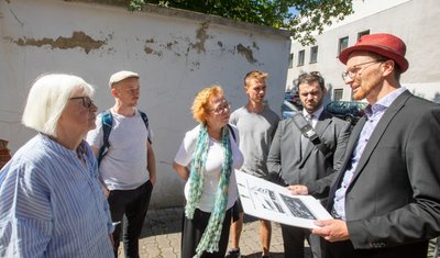 An der 90 Jahre alten Wand, die zur Synagoge gehörte, blättert der Putz ab. Und richtig standfest ist sie auch nicht mehr. Deshalb soll die Mauer saniert werden. Über diese Nachricht von Plauens Bürgermeister Tobias Kämpf (rechts) freuten sich die Ehrenamtler Liane Kümmerl und Jens Bühring sowie Ruth Röcher von der Jüdischen Gemeinde in Chemnitz, Jonas Hommel vom Verein Vois und Rabbiner Zsolt Balla (von links).