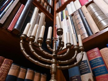            Ein Chanukkaleuchter steht in der "Stefan und Inge Heym Arbeitsbibliothek" vor den Büchern.
