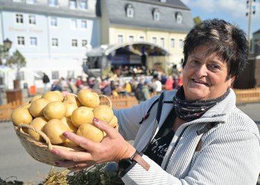 Silvia Weiße von der Katzensteiner Agrar GmbH mit einem Korb Kartoffeln.