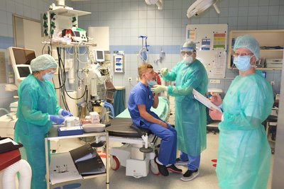 Mitarbeiter des LMK zeigen, wie ein Corona-Test vonstatten geht. 