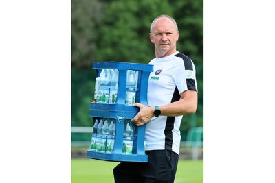 Thomas Romeyke beim Tragen von Wasserkästen.