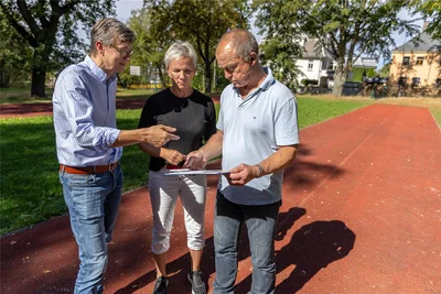 Schulamtsleiter Knut Kirsten (links) unterhält sich auf der maroden Laufbahn mit Sportlehrerin Andrea Fröba und Schulleiter Rainer Lemoine über die neuen Sportanlagen.