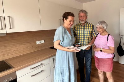 Susann Martin von der Volkssolidarität (l.) führt Stefan und Katrin Burkhardt durch eine Wohnung.