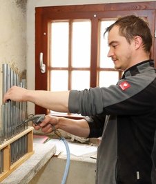 Andreas Kulitza reinigt mit Pressluft die einzelnen Orgelpfeifen.