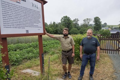 Toni Schilk und Konrad Meyer vom Heimatverein Schönbrunn an der Infotafel zum Bauernkrieg im Ambrossgut.