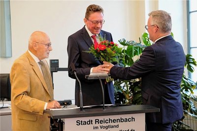 Nach der Vereidigung durch Peter Tillack (links) erhält der neue OB Henry Ruß Blumen von Thomas Höllrich.