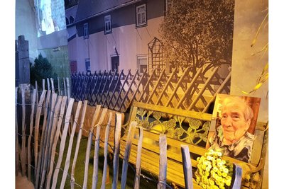 In der Schau sitzt Annie Dressel wieder auf der Bank zwischen dem Gartenzaun und ihrem Rodewischer Wohnhaus.