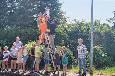 Zweitklässler der Grundschule Stenn beobachten das Anbringen des neuen Schildes ganz genau.