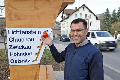 Thilo Meichsner an der Anzeigetafel für den gewünschten Zielort, die vom Hohndorfer Schmied Jens Braune angefertigt wurde.