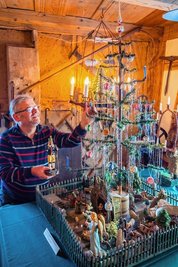 Museumsleiter Andreas Schubert an dem Weihnachtsbaum, bei dem die Äste aus Gänsefedern sind. Der stammt aus dem Jahr 1925. 