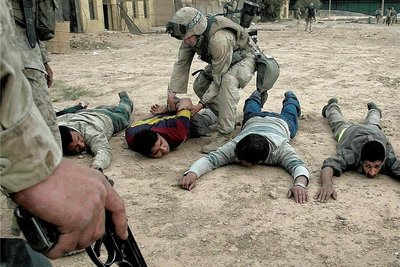 Mutmaßliche Plünderer, die in einer Bank gefasst wurden, werden von US-Soldaten durchsucht. 