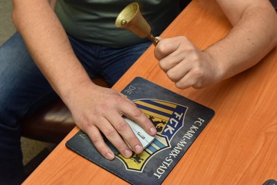 Ein aus dem Boxbereich stammende Sitzungsglocke und ein Mousepad eines Fußballteams erinnern an den sportlichen Job von Mittelsachsens Sportbundchef Benjamin Kahlert.