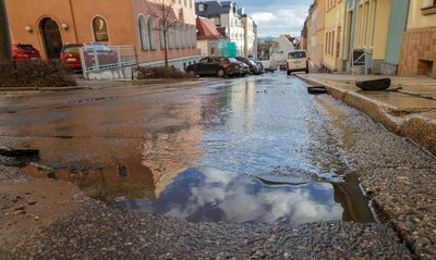 Durch das austretende Wasser eines Rohrbruchs wurde auf der Schulstraße die Asphaltdecke angehoben.