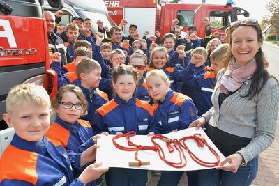 Geschäftsführerin Peggy Illgen (r.) von der gleichnamigen Bäckerei hat den 17 Mitgliedern der Jugendfeuerwehr  jetzt einen symbolischen Scheck über 400 Euro übergeben. Dabei handelt es sich um den Erlös aus dem Verkauf der Florianskruste, ein Sechs-Korn-Brot. Mit jeder verkauften Florianskruste gingen im März 20 Cent an die Jugendfeuerwehr.