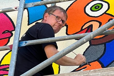 Der Künstler und sein Werk: Michael Fischer-Art bei der Arbeit am Wandbild des Freiberger Förderzentrums „Käthe Kollwitz“.