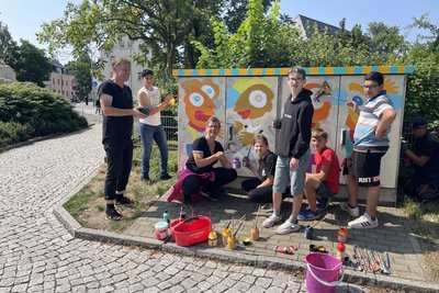 Der Maler Michael Fischer-Art bemalte 2023 mit Freiberger Förderschülern Stromkästen in der Bergstadt. Mit dabei: Lehrerin Anja Schmidt vom Förderzentrum „Käthe Kollwitz“, die die Aktion organisiert hat.